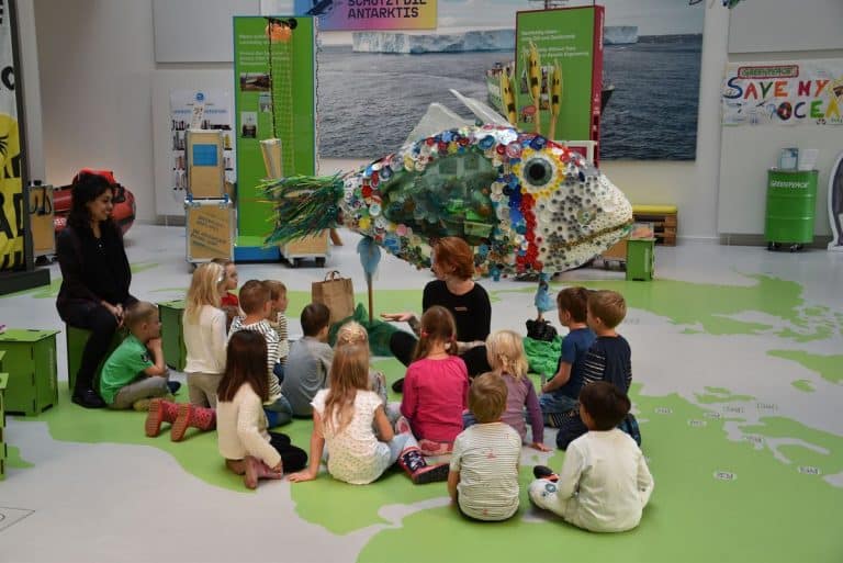 Kinder sitzen im Kreis bei Greenpeace