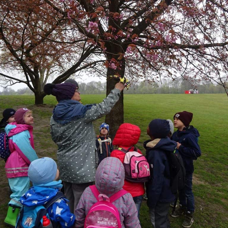 Kinder betrachten einen blühenden Baum
