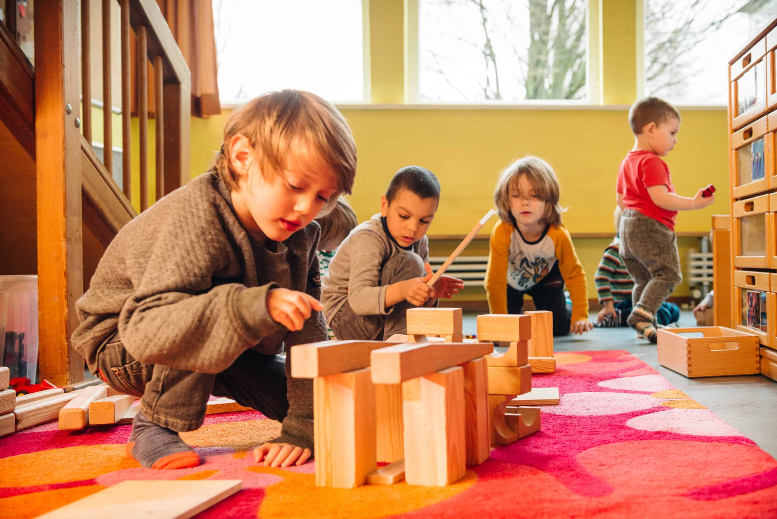 Kinder mit Holzbausteinen im Bauraum