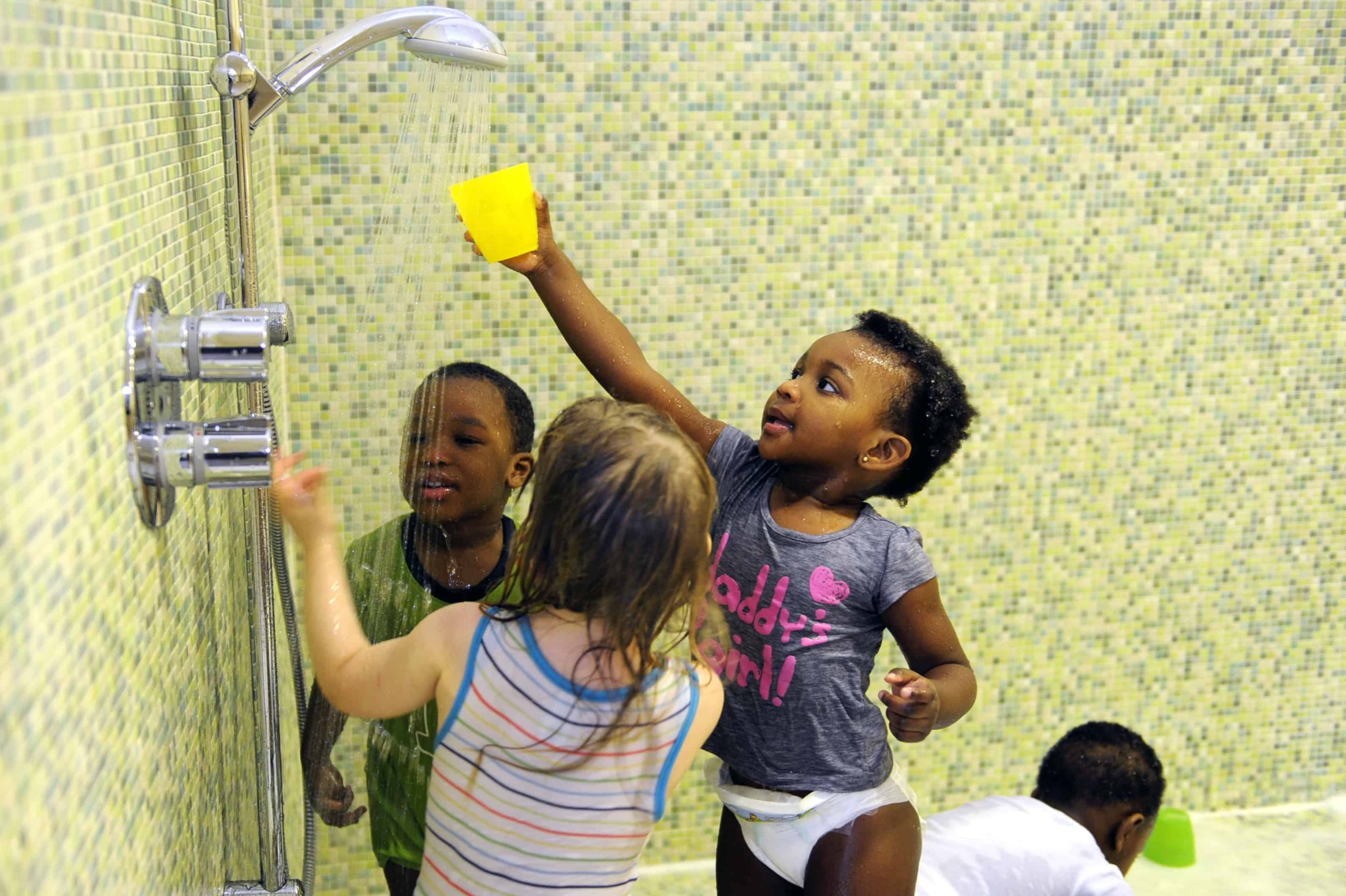 Kinder spielen mit Wasser an der Dusche