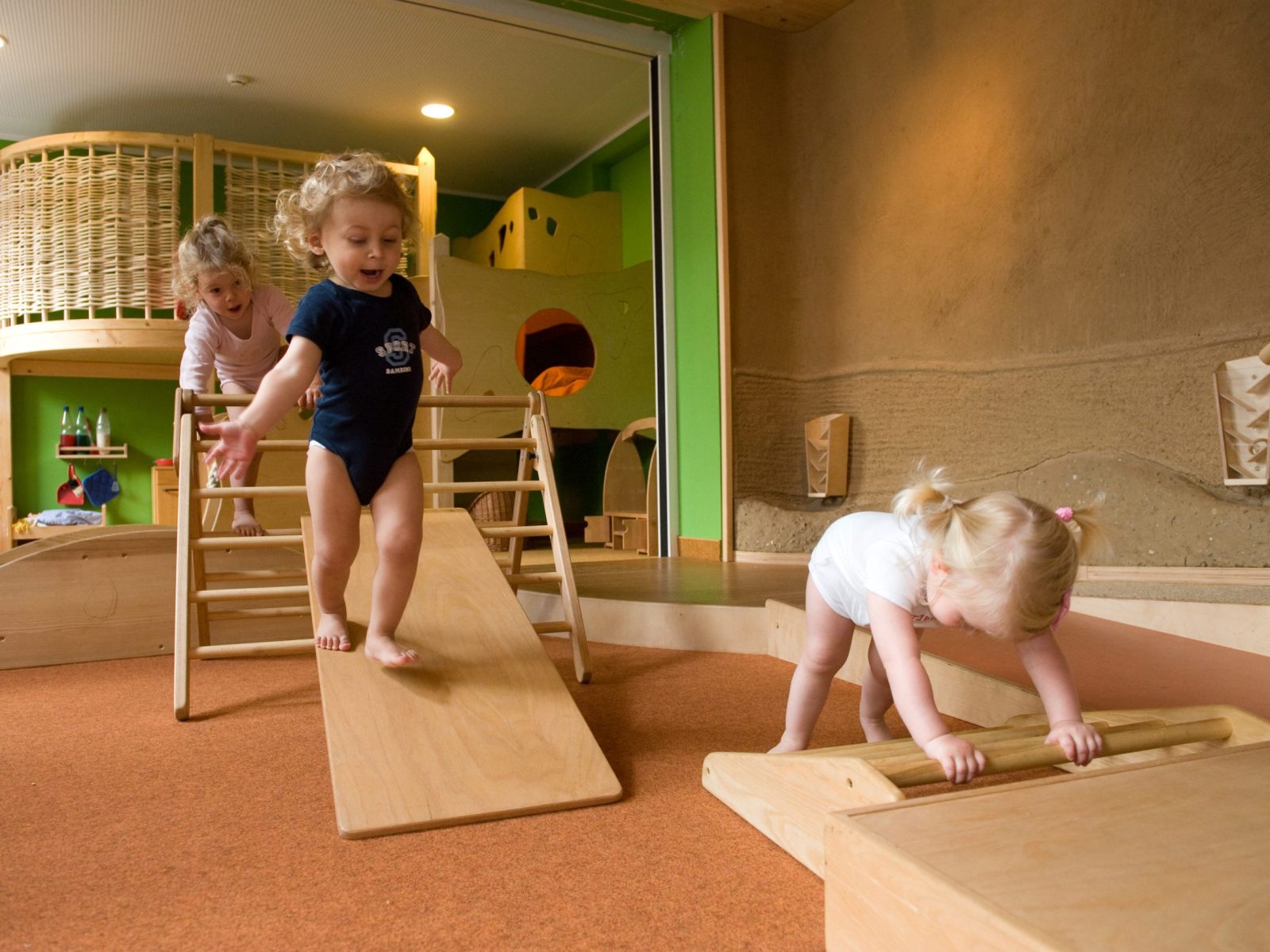 Children climb and run on Pikler devices